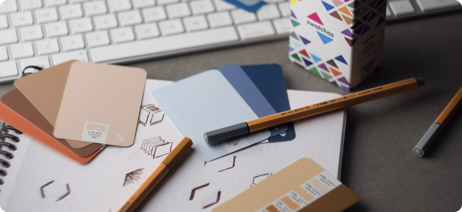 Colour swatches, pencils and sketches on a desk